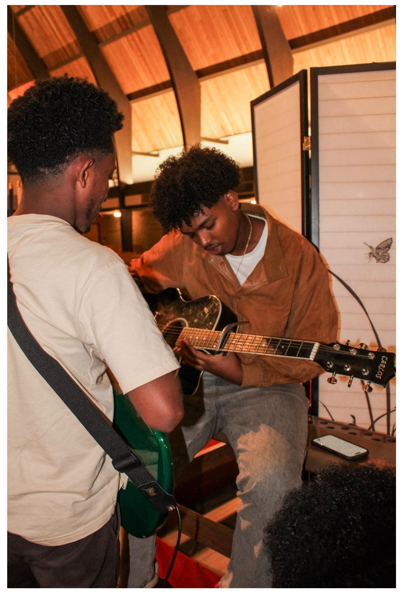 Two young guitarists playing together during a worship gathering