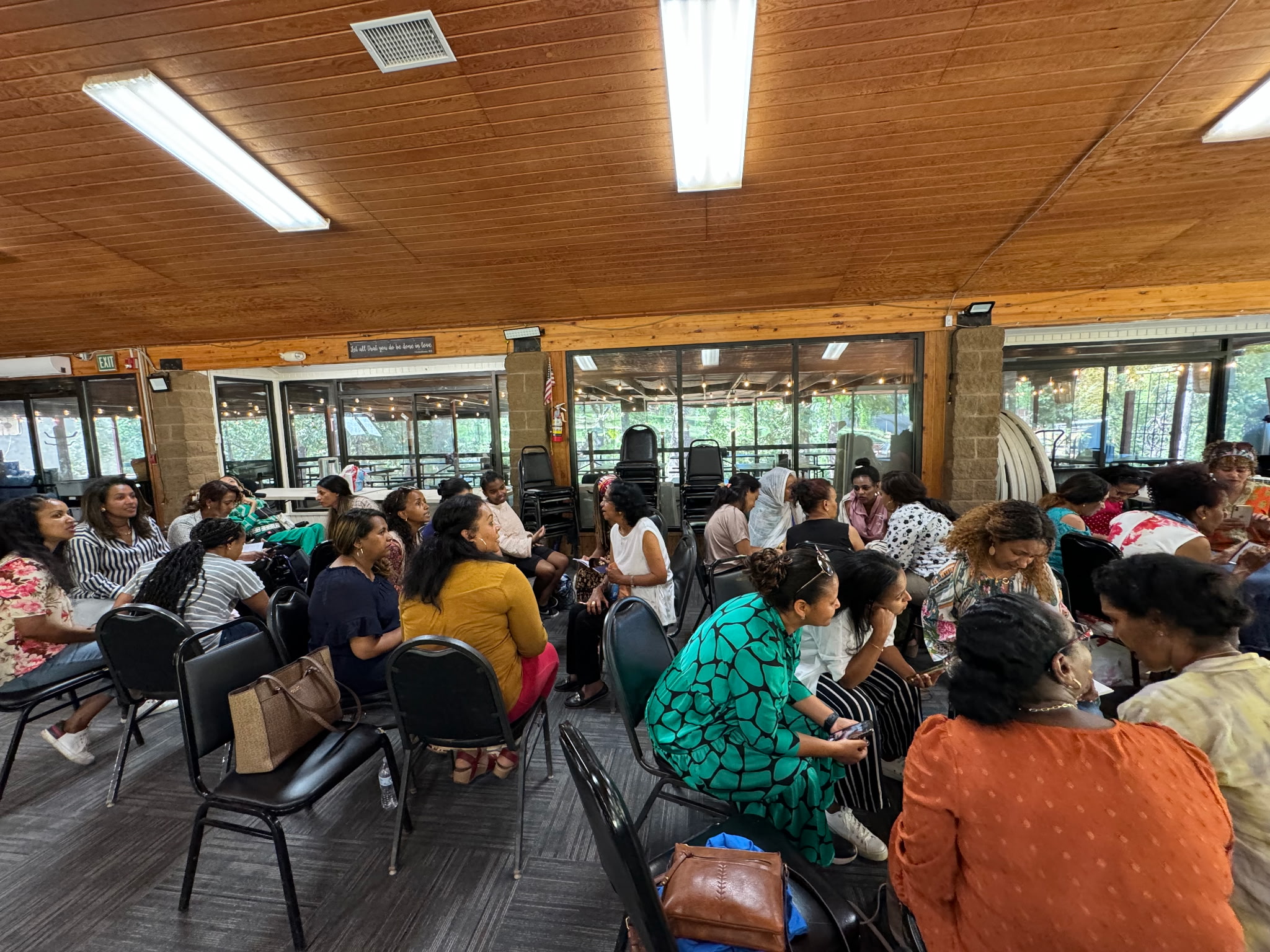 Women seated in small discussion groups during a fellowship gathering in a lodge hall